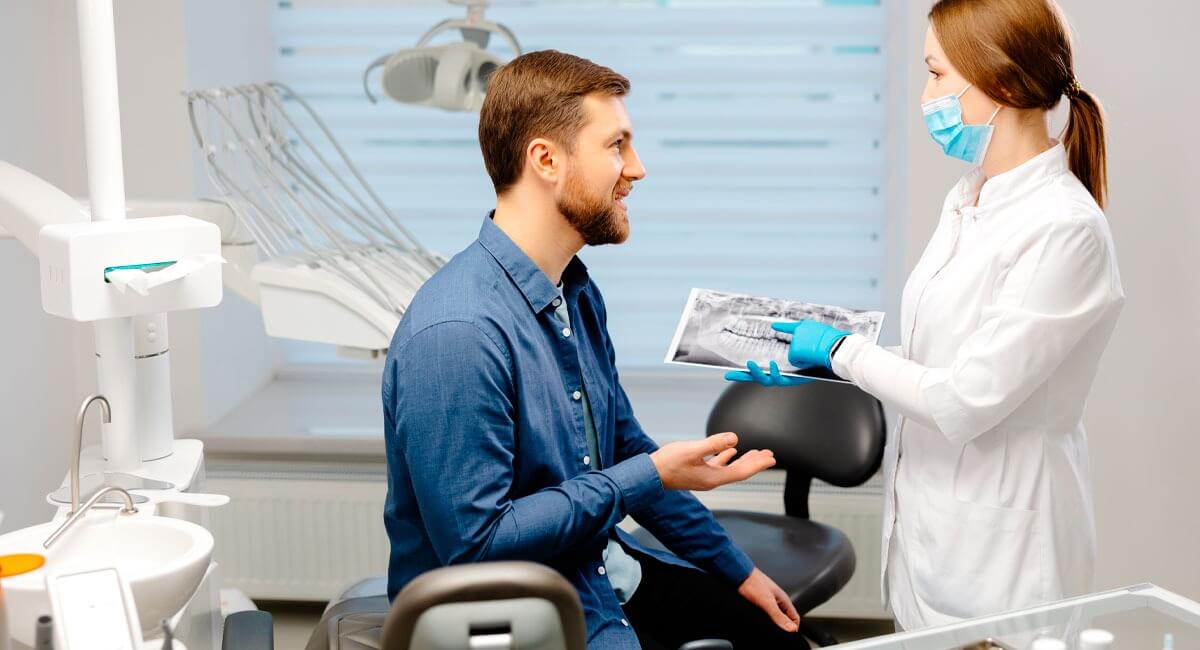 Patient with dentist looking at teeth xray