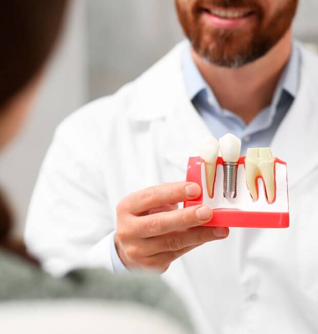 Patient with dentist reviewing dental implants procedure