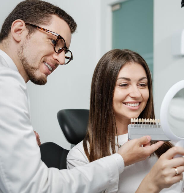 Dentist showing patient dental veneers options