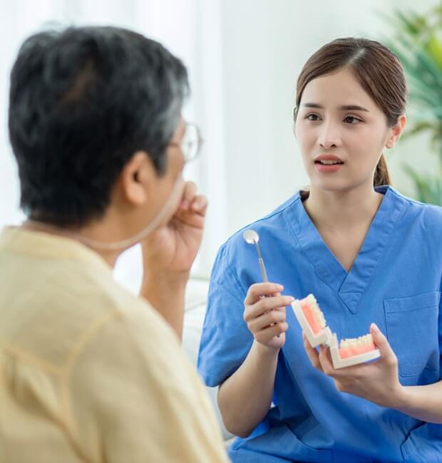 Dentist explaining how dentures work and cleaning them