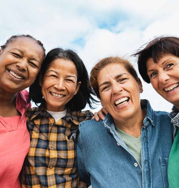 A group of retired women smiling and hugging