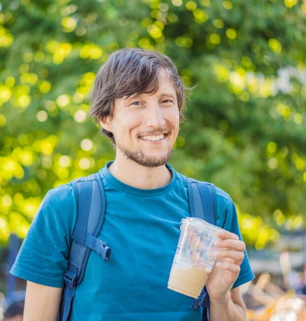 A patient after a wisdom teeth extraction with a ice coffee