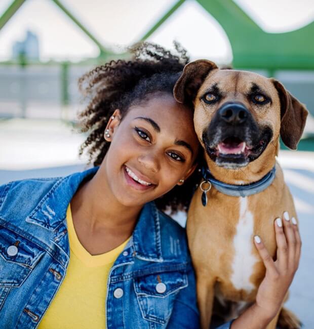 A smiling Viva Dental Group Orangeville patient with her dog enjoying the sunshine